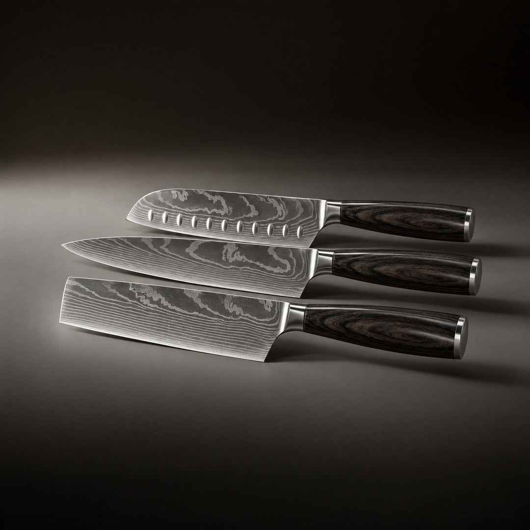 Die drei Messer liegen nebeneinander auf einer dunklen Fläche, die Klingen mit Wellenmuster zeigen zur linken Seite, die Griffe nach rechts. 2