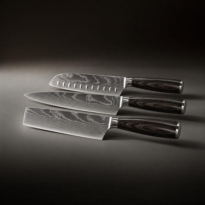Die drei Messer liegen nebeneinander auf einer dunklen Fläche, die Klingen mit Wellenmuster zeigen zur linken Seite, die Griffe nach rechts. 2