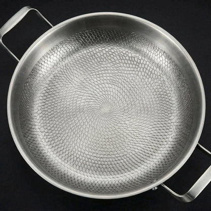 Draufsicht auf die leere Pfanne, die das spiralförmige, wabenartige Hammerschlagmuster im Innenboden in Nahaufnahme zeigt. 2