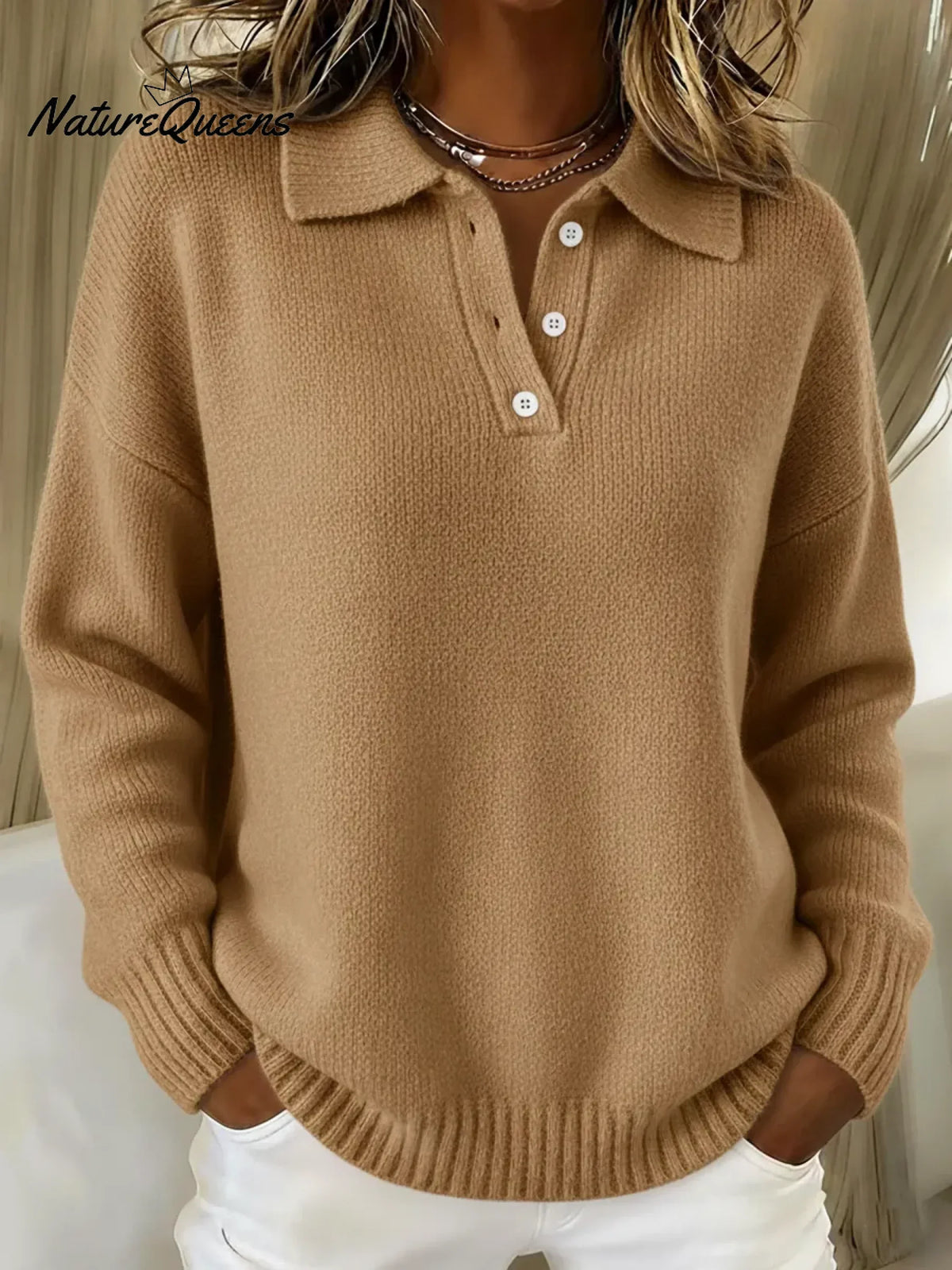 Pullover mit Polokragen in Camel- bzw. Sandbraun, getragen von einer Frau, mit Knopfleiste und gerippten Ärmelbündchen. 4