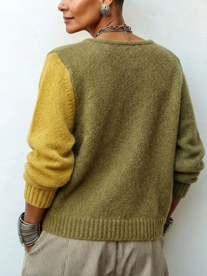 Rückansicht des Strickpullovers: Rücken und rechter Ärmel in Oliv, linker Ärmel in Senfgelb, mit gerippten Bündchen und Saum. 2