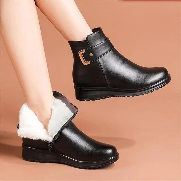 Schwarze Stiefeletten von einem Model getragen, ein Stiefel mit weißem Plüschfutter und Reißverschluss vor rosigem 4