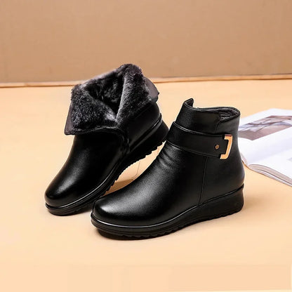 Schwarze Lederstiefeletten mit goldener Schnalle, ein Stiefel mit umgeschlagenem dunklem Plüschfutter, daneben aufgeschlagene 1