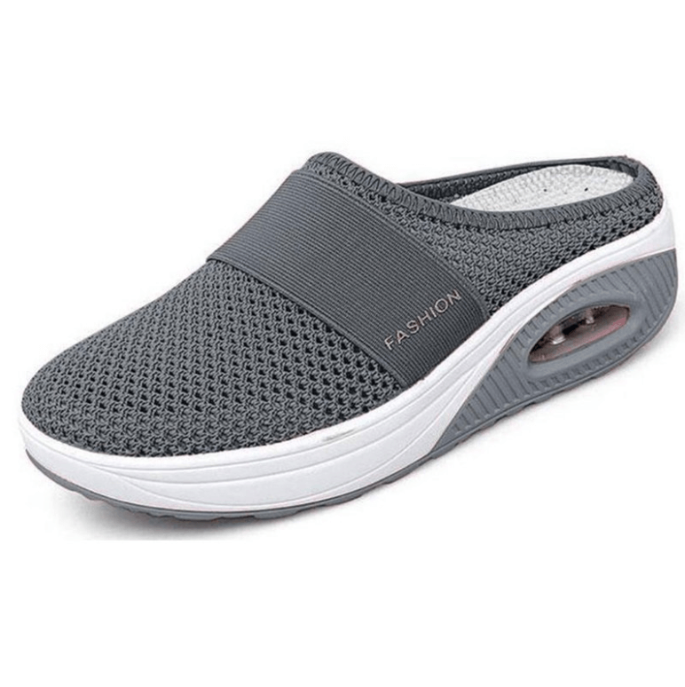 Grauer Slipper aus Netzgewebe mit elastischem Band und weißer Sohle, schräg von vorn 1