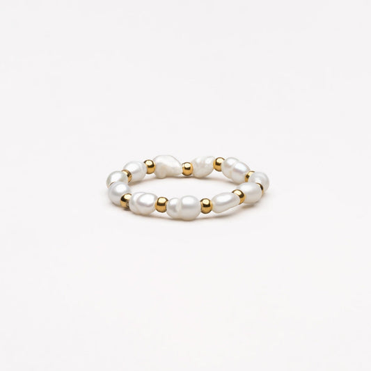 Perlenring mit goldenen Akzenten, eleganter Schmuck, weiß, modisch, Damenaccessoire.