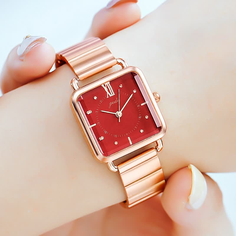 Roségoldene Armbanduhr mit rotem Zifferblatt, quadratischem Gehäuse und Metallarmband.