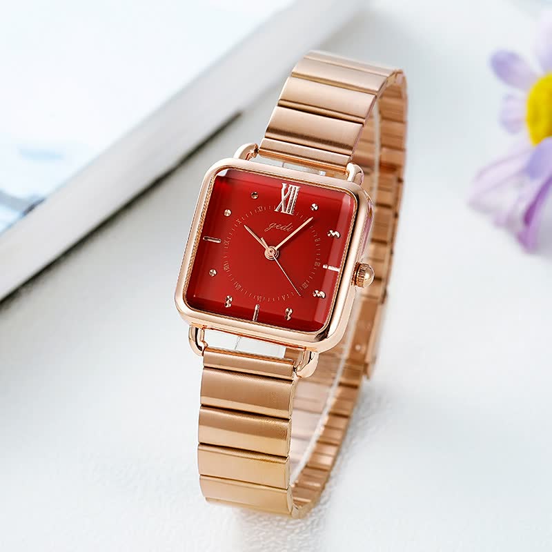 Roségoldene Damenuhr mit rotem Zifferblatt, quadratischem Gehäuse und Metallarmband.