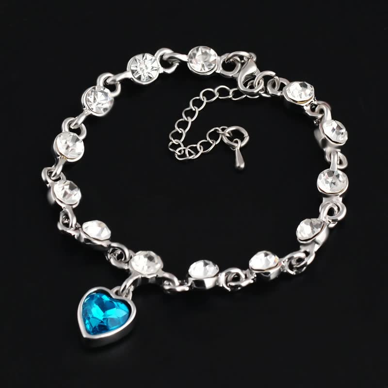 Silberarmband mit blauen Herzanhänger und klaren Kristallen, eleganter Schmuck für Damen.