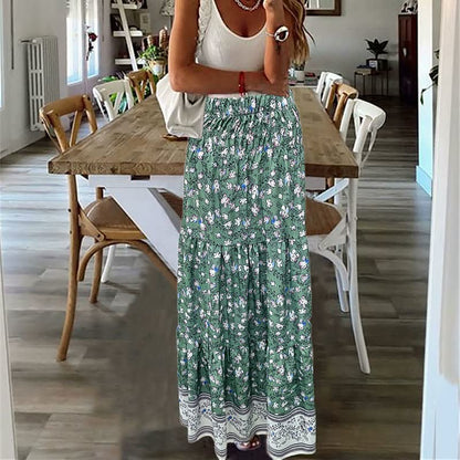 Frau in grünem Maxirock mit Blumenmuster, weißem Top, in modernem Esszimmer.
