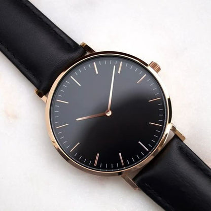 Luxus Herrenuhr mit schwarzem Zifferblatt, goldfarbenem Gehäuse und schwarzem Lederarmband.