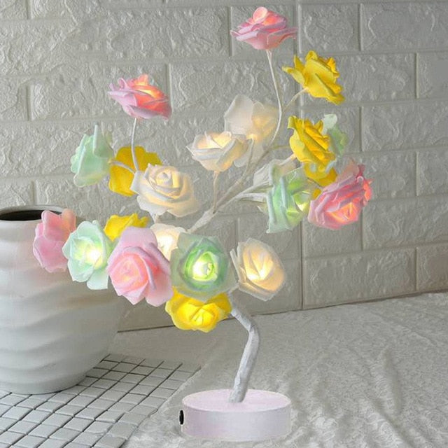 Bunte LED-Rosenlampe auf Tisch, dekorative Beleuchtung, romantisches Ambiente, Wohnzimmer-Deko.