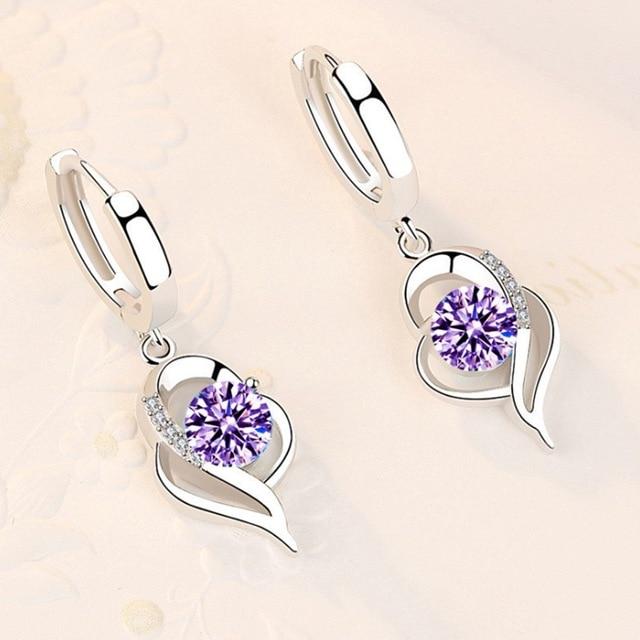 Silberne Ohrringe mit lila Kristallen, Herzform, elegantes Schmuckdesign für Damen.