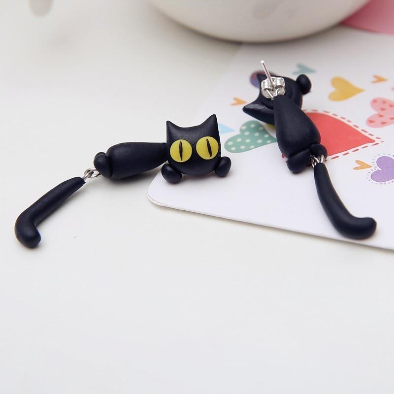 Schwarze Katzen-Ohrringe aus Polymer, handgefertigt, mit gelben Augen, auf weißem Hintergrund.
