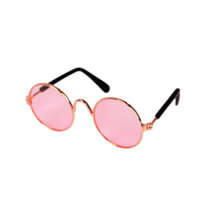 Runde Sonnenbrille mit rosafarbenen Gläsern und goldfarbenem Rahmen, modisch, retro.