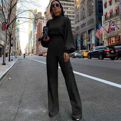 Frau in schwarzem Jumpsuit auf Stadtstraße, Mode, eleganter Look, urbane Kulisse.
