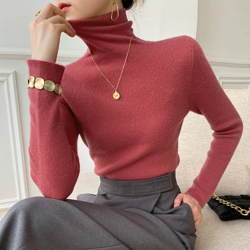 Rollkragenpullover in Rostrot am Model, kombiniert mit grauem Rock und goldenem Armband 2