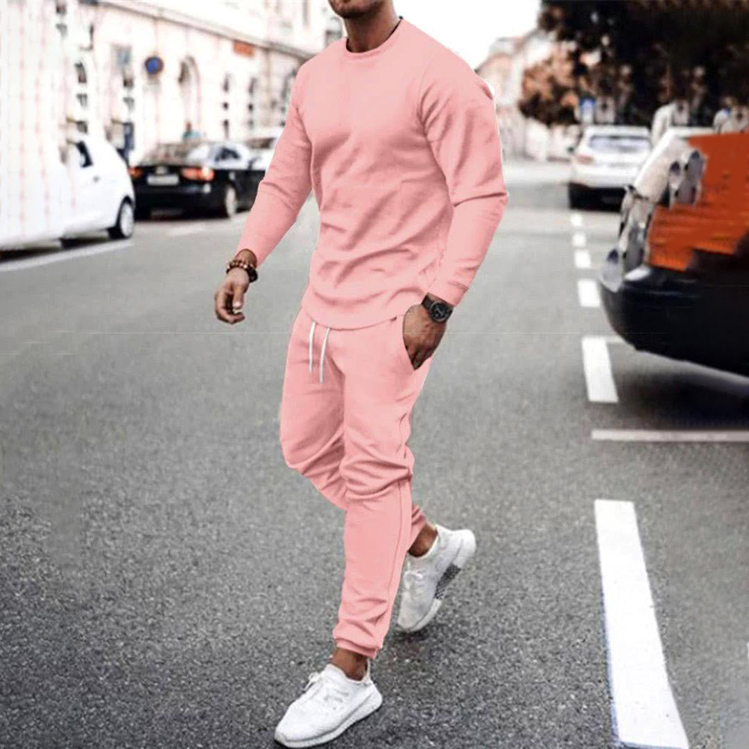 Mann in rosa Jogginganzug auf Straße, sportlich, bequem, Freizeitmode, Herrenbekleidung.