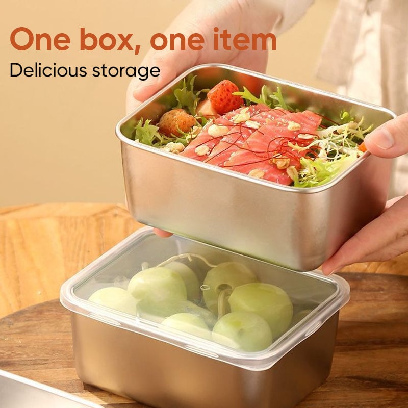 Hände halten eine Edelstahlbox mit Salat, Lachs und Erdbeeren über einer zweiten Box mit Trauben unter durchsichtigem Deckel. 5