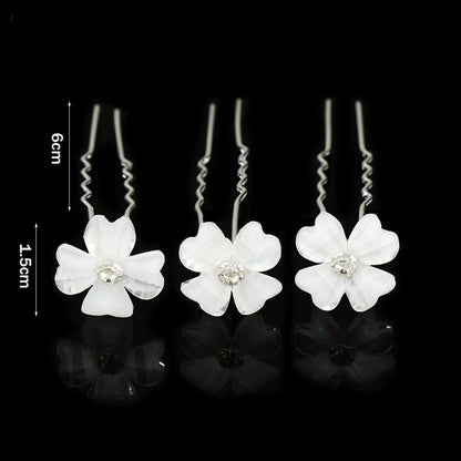 Drei weiße Haarspangen mit Blumen und Strasssteinen, 6 cm lang, auf schwarzem Hintergrund.