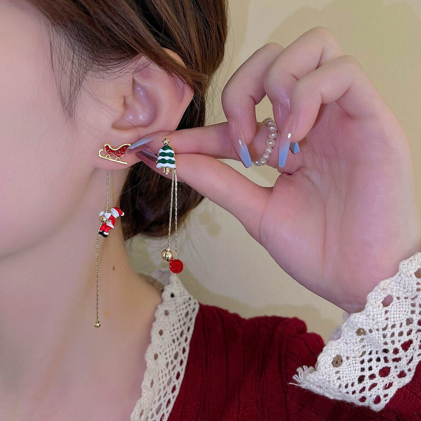 Frau mit Weihnachts-Ohrringen, Schlitten und Tannenbaum-Design, goldene Kette, festlicher Schmuck.
