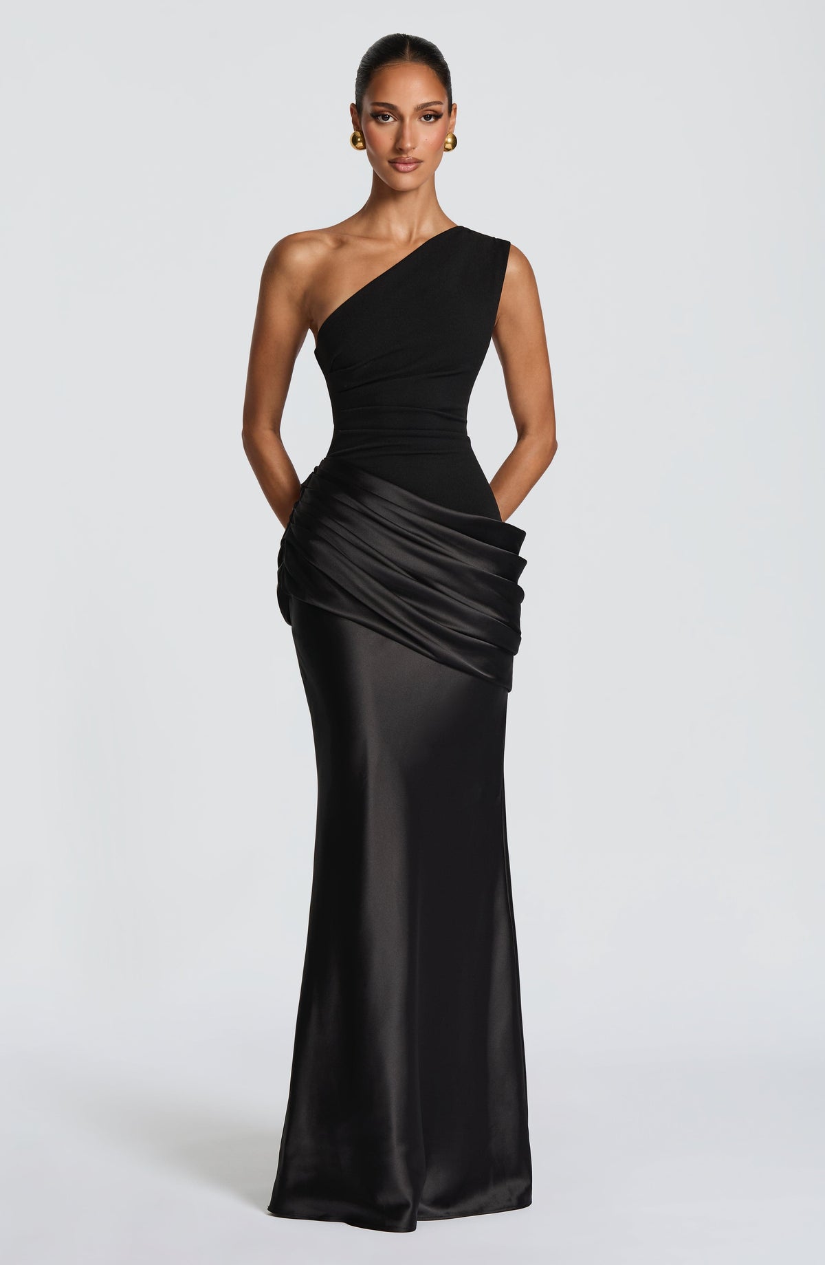 Schwarzes Maxikleid mit einer Schulter und gerafftem Satinrock, Model frontal mit goldenen Ohrringen und hochgestecktem Haar. 20
