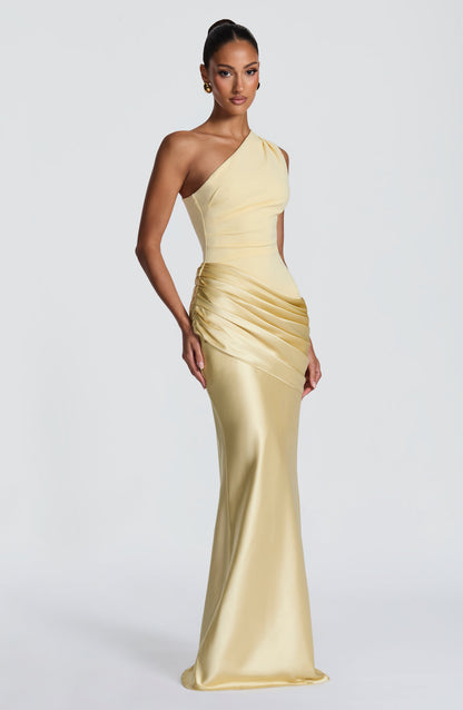 Hellgelbes Maxikleid in Dreiviertelansicht, die gerafften Falten an der Hüfte und der glänzende Satin sind gut zu erkennen. 28