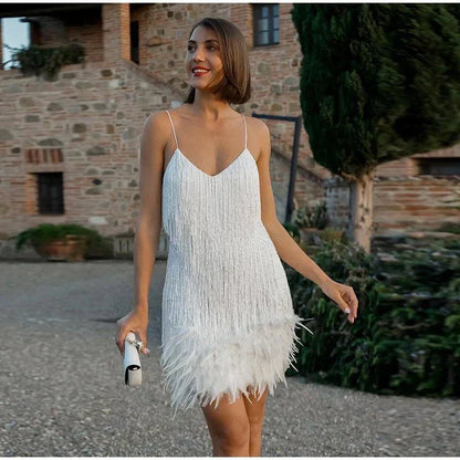 Frau im weißen Cocktailkleid mit Federn, elegantes Abendoutfit, draußen, stilvoll.
