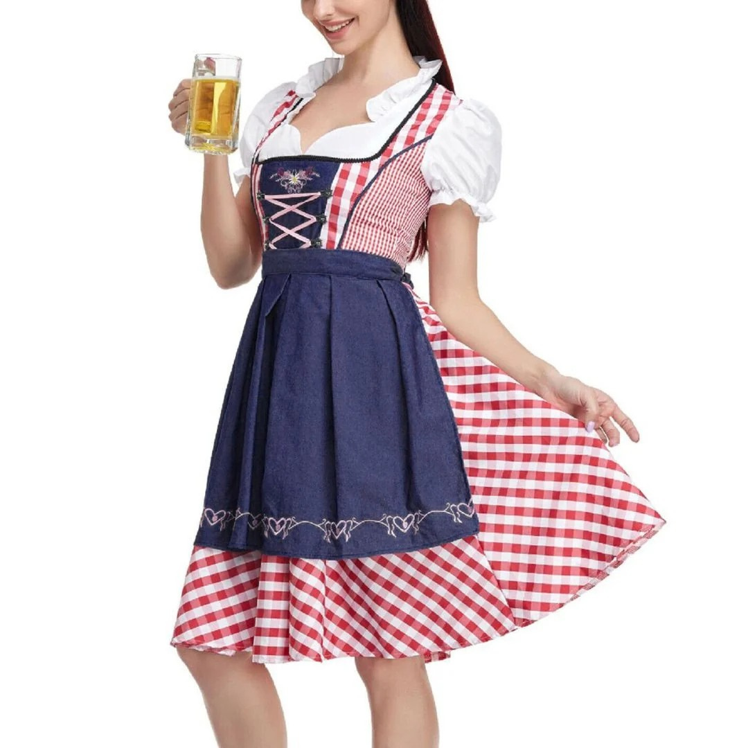 Model hält einen Bierkrug und trägt das Dirndl mit marineblauer Schürze, rot-weiß kariertem Rock und rosa Schnürung. 2