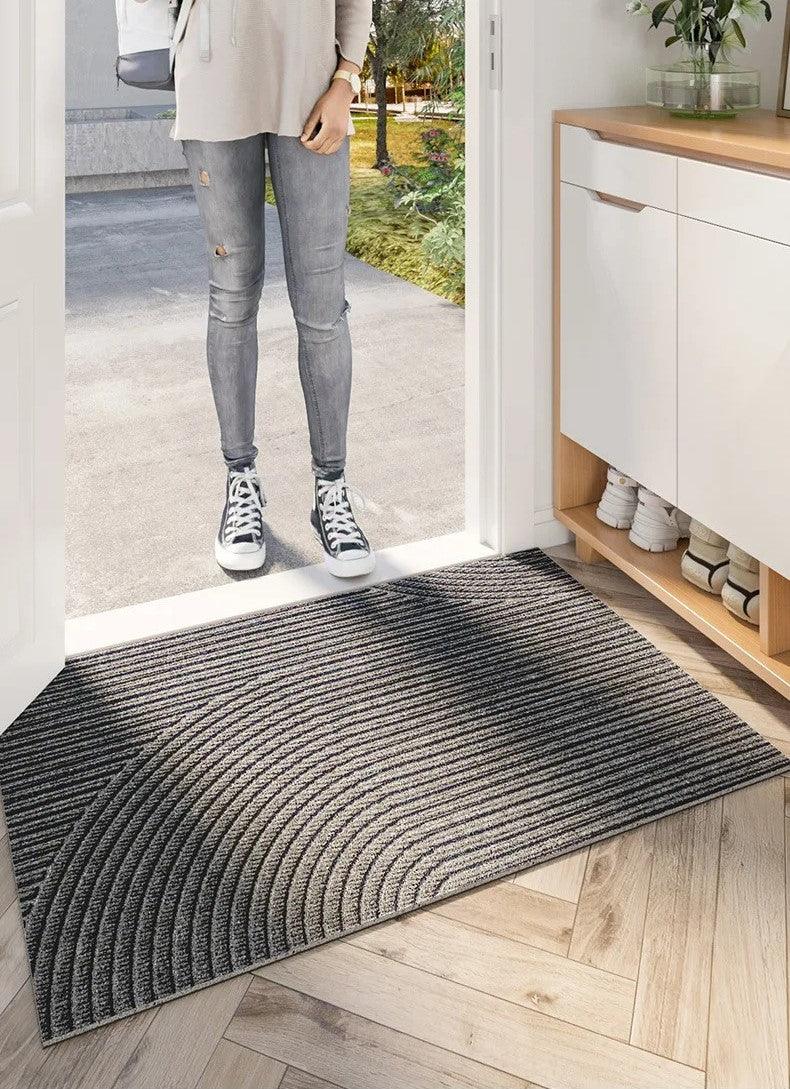 Person in Sneakern und Jeans steht an der Tür vor einer grau gestreiften Fußmatte 8