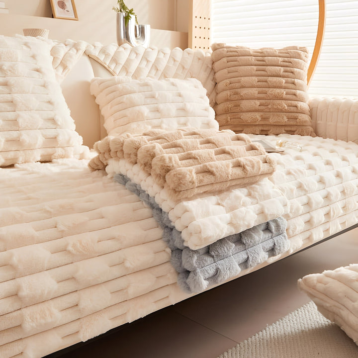 Sofa mit cremeweiĂźer Decke und Kissen, dazu gefaltete Decken in Beige und Grau als weitere Farboptionen. 7