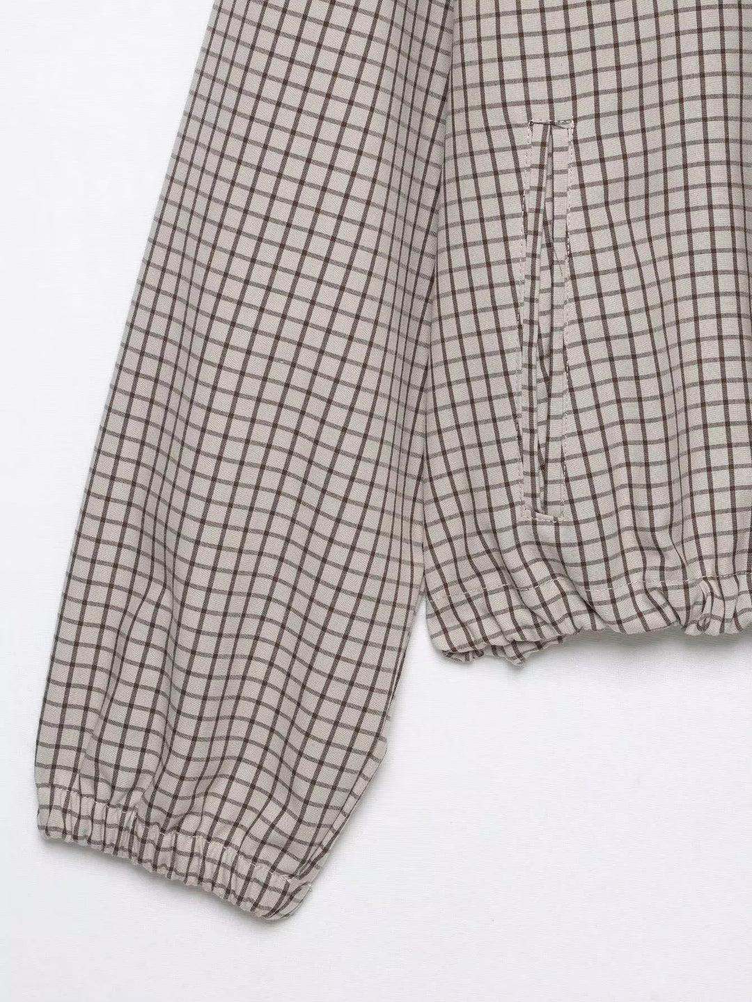Detail von Ärmel und Saum: elastisches Ärmelbündchen, gerafftes Saumende und seitliche Eingrifftasche im Karomuster. 8