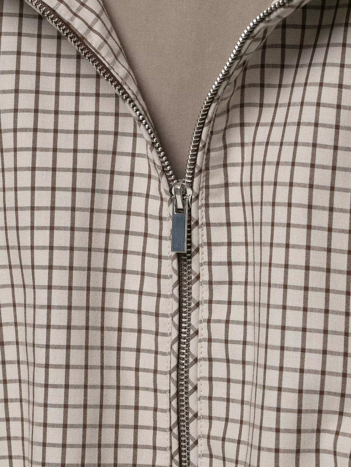 Detailaufnahme des geöffneten Metallreißverschlusses mit Zipper vor dem karierten Stoff. 6