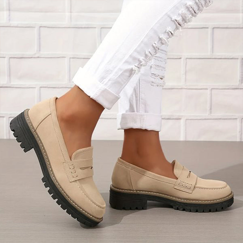 Beige Loafer mit grober Profilsohle an den Füßen, kombiniert mit weißer zerrissener Jeans, einer Fuß leicht angehoben. 3