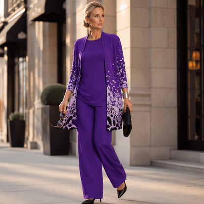 Model in violettem Set mit gemustertem Cardigan, weiter Hose und schwarzen Pumps, mit Clutch und Sonnenbrille auf einer Straße. 12