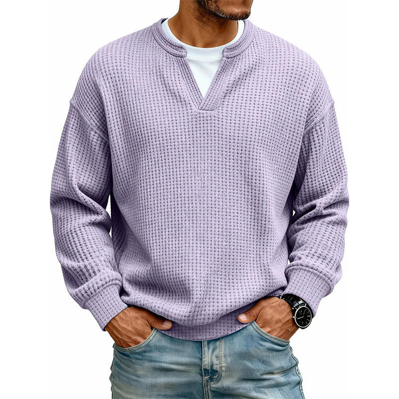 Frontansicht des Oberteils in Flieder am Model, mit weißem Shirt unter dem V-Ausschnitt, Hände in den Jeanstaschen. 19