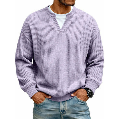 Frontansicht des Oberteils in Flieder am Model, mit weißem Shirt unter dem V-Ausschnitt, Hände in den Jeanstaschen. 19