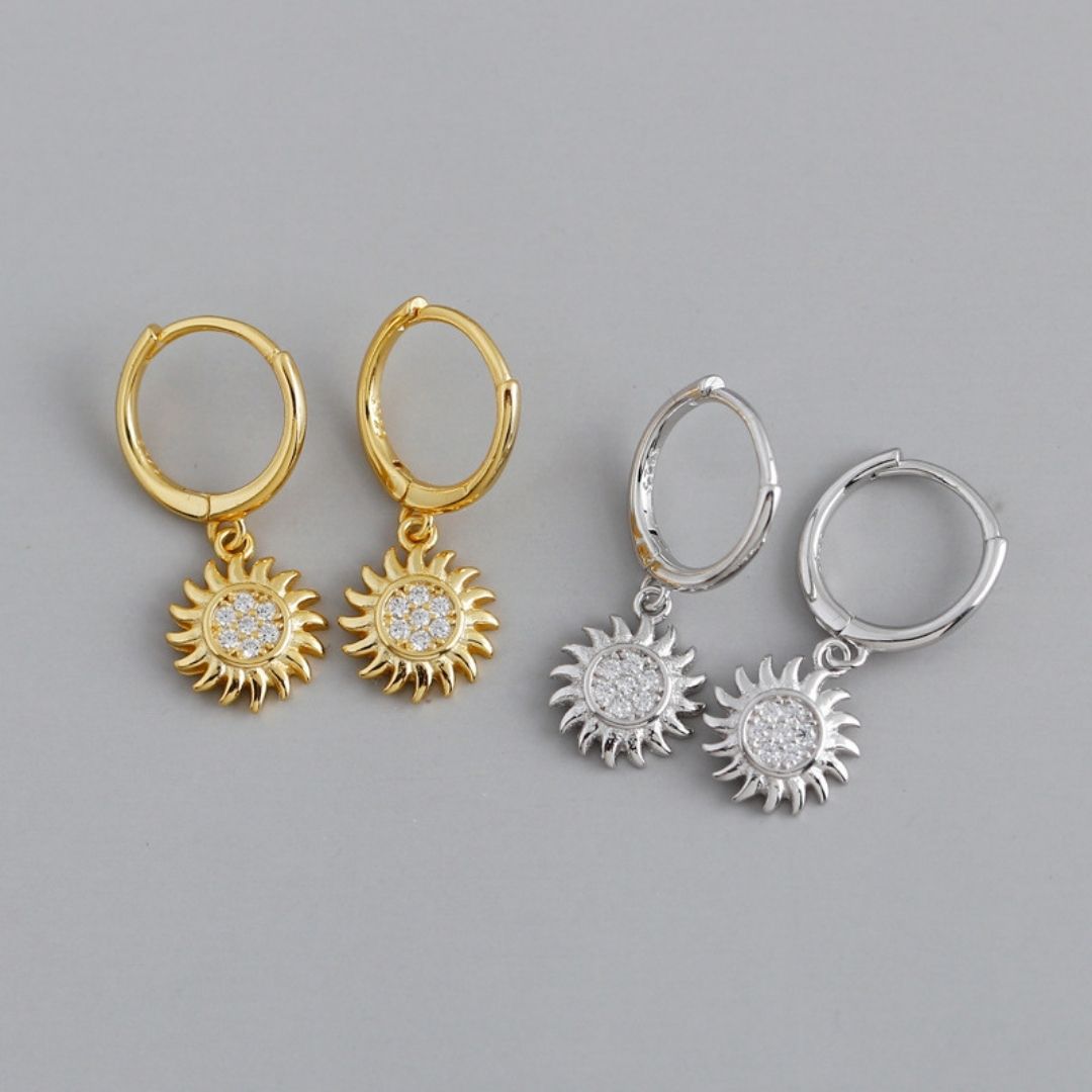 Goldene und silberne Sonnen-Creolen mit Strass, modische Ohrringe, Schmuckaccessoire.