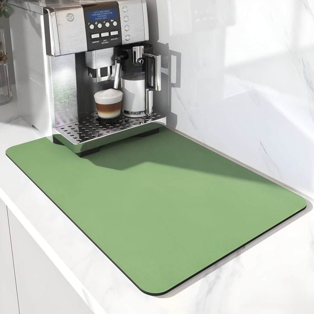 Grüne einfarbige Unterlage mit abgerundeten Ecken unter einem Kaffeevollautomaten mit gefülltem Kaffeeglas auf weißer Arbeitsplatte. 6