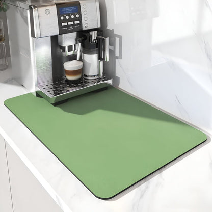 Grüne einfarbige Unterlage mit abgerundeten Ecken unter einem Kaffeevollautomaten mit gefülltem Kaffeeglas auf weißer Arbeitsplatte. 6
