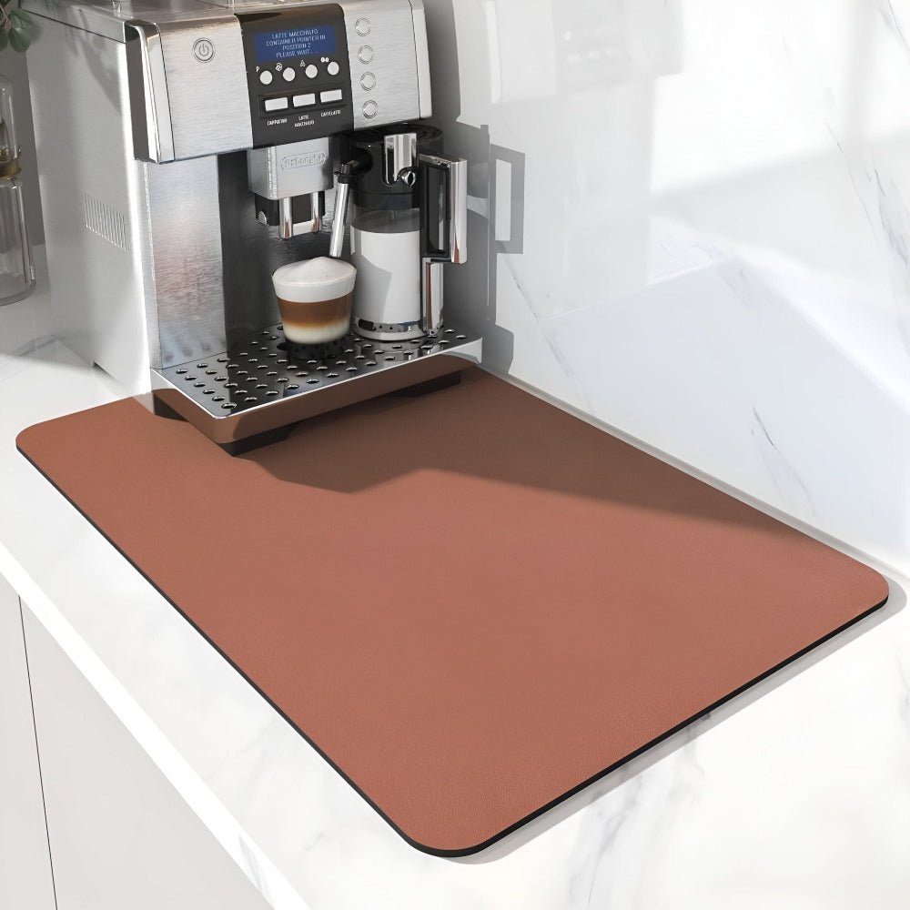 Rotbraune, terrakottafarbene Unterlage unter einem Kaffeevollautomaten mit Milchbehälter, schräg von der Seite auf weißer Arbeitsplatte fotografiert. 10