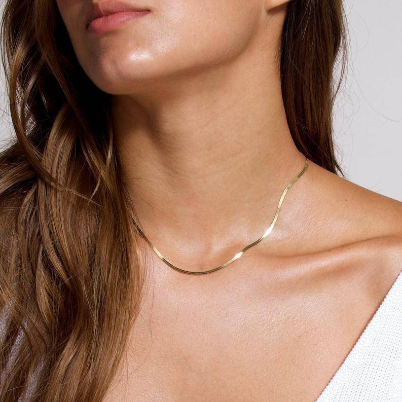 Frau trägt goldene 3mm Halskette, elegantes Schmuckstück, minimalistisches Design.