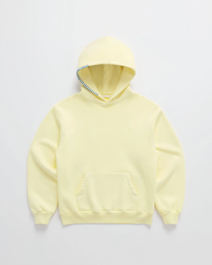 Hellgelber Kapuzenpullover von vorn auf hellem Grund, mit Kängurutasche und blauer Zickzack-Naht am Kapuzenrand. 1
