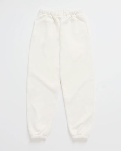 Cremeweiße Jogginghose mit Gummibund, seitlichen Taschen und elastischen Beinabschlüssen, flach ausgelegt. 7