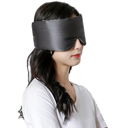 Frau trägt schwarze Seidenschlafmaske, ideal für Schlaf und Entspannung.
