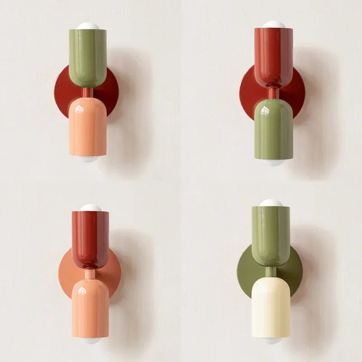 Vier Farbvarianten der Wandleuchte im Vergleich, nebeneinander an heller Wand: Grün, Rot, Rosa und Creme in unterschiedlichen Kombinationen. 12