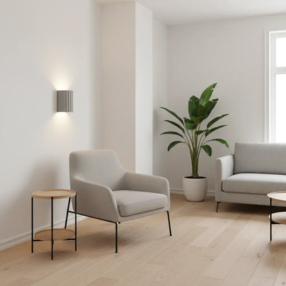 Graue gerillte Wandleuchte in hellem Wohnzimmer neben Sessel, Beistelltisch, Sofa und Zimmerpflanze 5