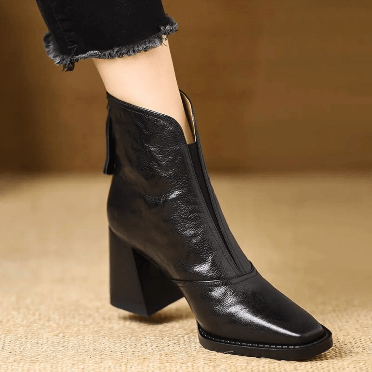 Schwarze Lederstiefelette mit quadratischer Spitze und Blockabsatz, seitlich getragen zu schwarzer Jeans mit ausgefranstem 2
