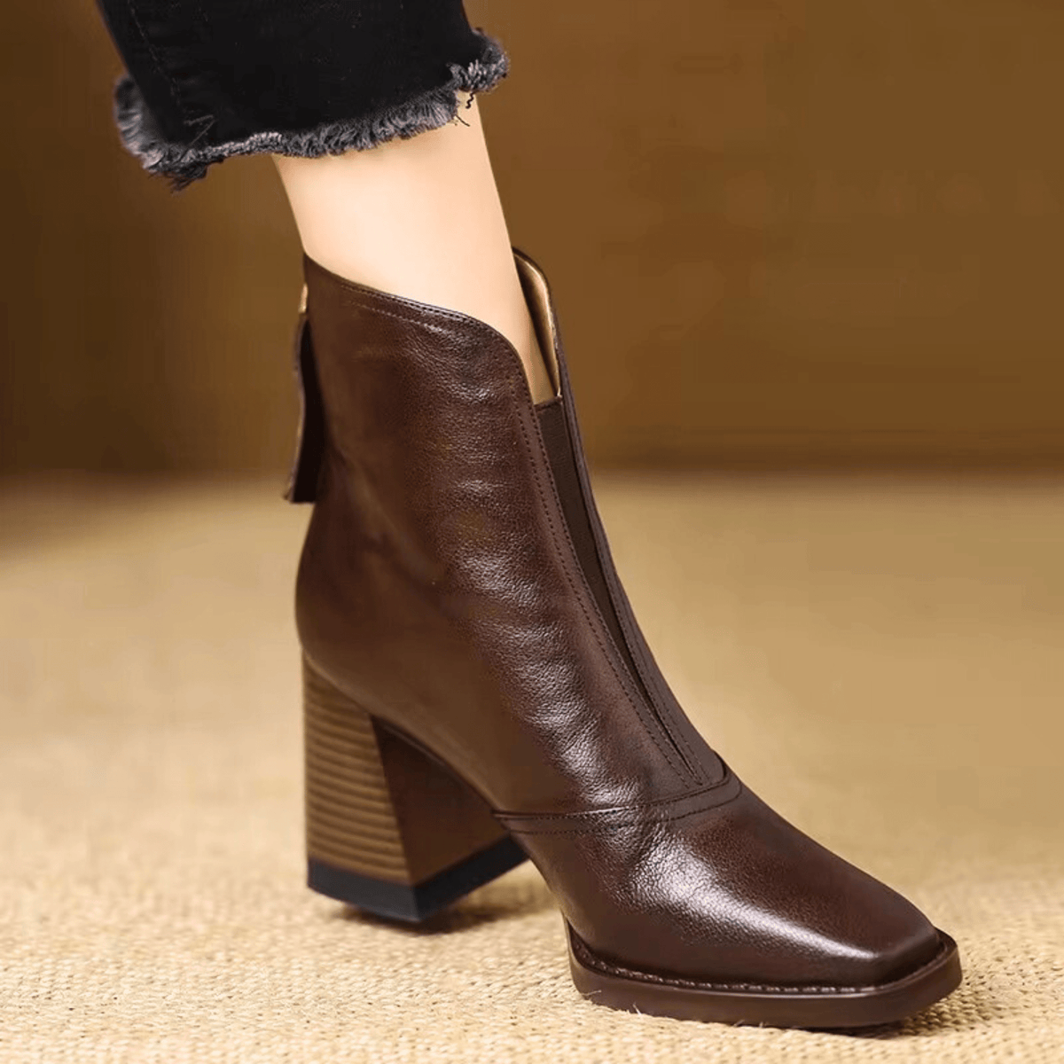 Braune Lederstiefelette mit quadratischer Spitze und Holzoptik-Blockabsatz, getragen zu schwarzer Jeans mit ausgefranstem 1