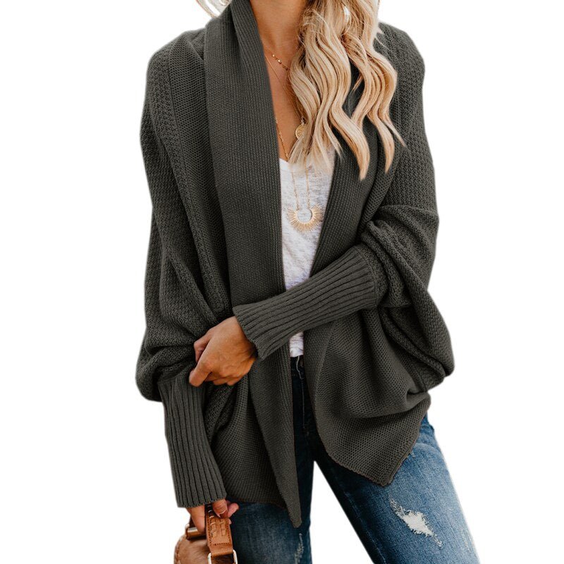 Frau in olivgrünem Strickcardigan, lässig, langärmelig, über weißem T-Shirt und Jeans.