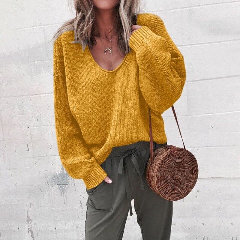 Frau in gelbem V-Ausschnitt Strickpullover, lässig, mit runder Strohtasche, modisch.